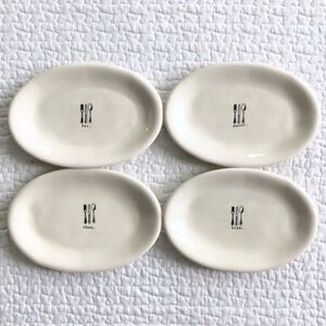Set 4 Rae Dunn oval appetizer plates plus cute daisy napkins by Betsey Johnson.